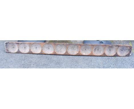 A vintage Indian spice vending/grinding tray with ten circular depressions (243cm x 22.5cm)