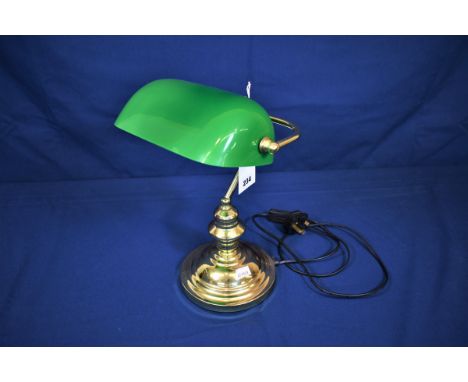 A brass desk lamp with green glass shade. 