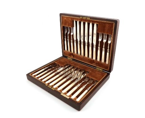 A set of twelve silver fruit knives and forks, by Walker and Hall, Birmingham 1933,tapering mother-of-pearl handles, the blad