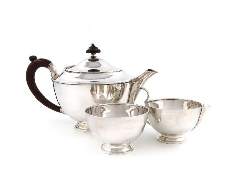 A three-piece silver tea set,by Goldsmiths &amp; Silversmiths Co, London 1938,circular form, wooden scroll handle, the hinged