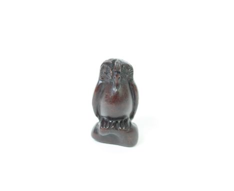 A carved wooden netsuke of a standing owl