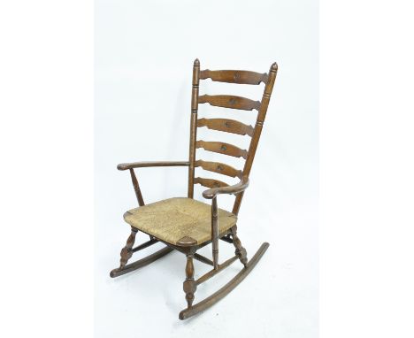 An oak framed rocking ladder back rocking chair