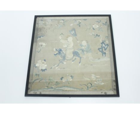 A Chinese silk embroidery of children playing, with one riding a dragon, 44cm high, 41cm wide