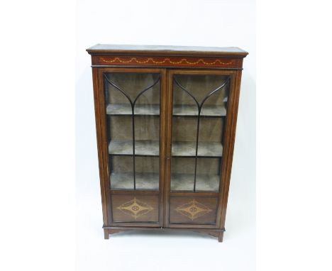 An early 19th century inlaid two door glazed cabinet, raised in bracket feet, 140cm high, 94cm long, 33cm deep