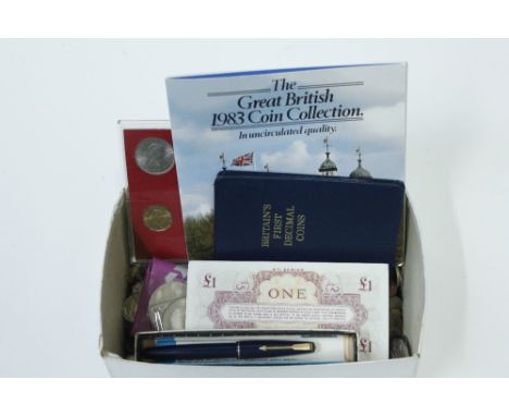 A small collection of coins, along with two fountain pens and silver plated drinks labels