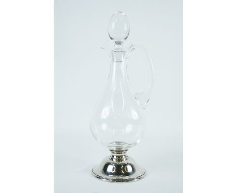 A glass decanter standing on circular hallmarked silver base