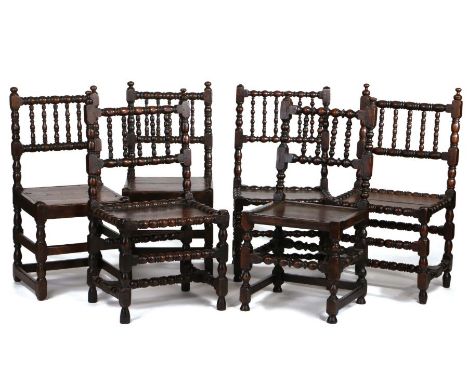 Matched set of six Charles II oak ‘bobbin’-turned chairs, circa 1670, capped with finials above the bobbin turned backs, soli