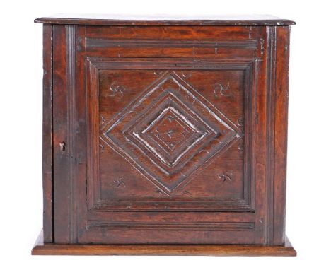 Charles II oak table cabinet, Lancashire, circa 1670, having a  one-piece top with ovolo-moulded edge, a single panelled door