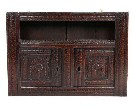 Charles I oak mural glass case livery cupboard, West Country, circa 1640, the rectangular plank top above an open canopy and 