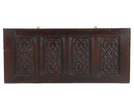 A Charles I carved oak panel, circa 1640, formerly part of a coffer, designed with four panels, each carved with a scrolling 