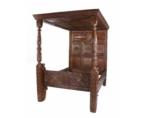 An impressive James I oak tester bed, West Country, dated 1614, having a twelve panel floral and lozenge carved tester, the h