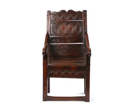 Charles II oak panel-back open armchair, Welsh, circa 1670, the back formed from two panels, the upper panel carved with inte