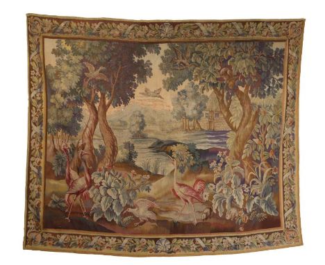 An 18th century tapestry, French, designed with cranes, crows and rabbits in a woodland, a thatched cottage in the background
