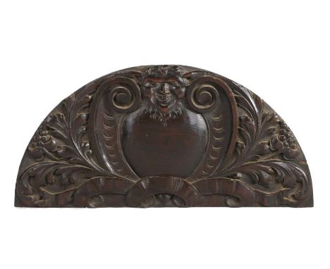 17th Century oak architectural carving, possibly a door pediment, the arched panel designed with Bacchus to the top above a b