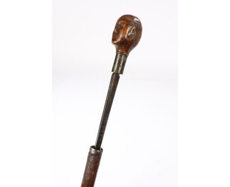 19th Century Folk Art sword stick, the treen human carved head above the blue steel blade and thorn scabbard, associated, 88c