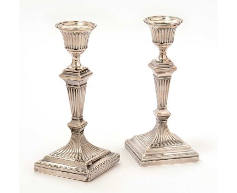 A pair of George V silver candlesticks, by William Hutton &amp; Sons Ltd, London 1910, with fluted sconces, stems and bases, 