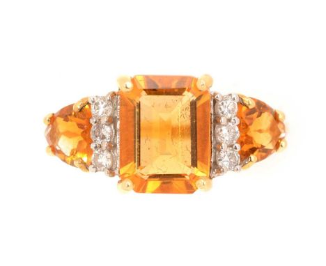 A citrine and diamond ring, the central rectangular step cut citrine measuring 9 x 6.7 x 4.2mm, flanked by trilliant cut citr