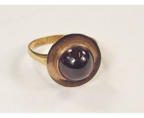 GOLD RING. A Victorian 18ct. gold ring, with applied cabouchon garnet. Size Q. (Top appears to have been added to the shank).