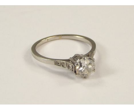 DIAMOND RING. A platinum solitaire diamond ring, the stone of approx. 0.08ct. spread in a coronet setting. Each shoulder diam