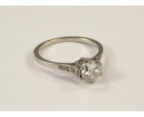 DIAMOND RING. A platinum solitaire diamond ring, the stone of approx. 0.08ct. spread in a coronet setting. Each shoulder diam