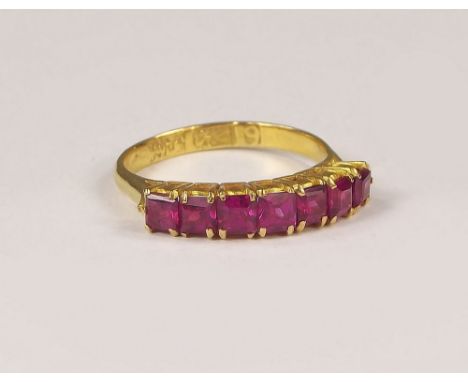 GOLD RING. A gold ring (Middle Eastern marks) with seven square cut, possibly synthetic rubies. Size K.