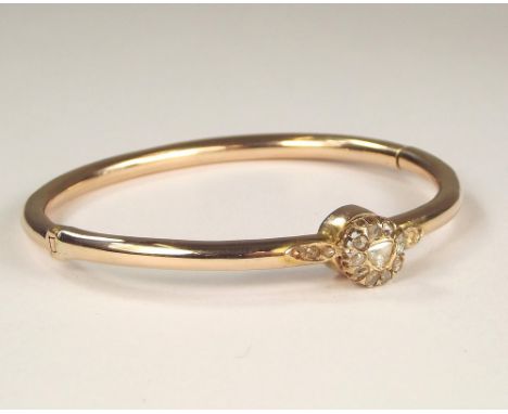 DIAMOND BANGLE. A yellow metal hinged bangle, set with various old cut diamonds. Approx. 12.4g.