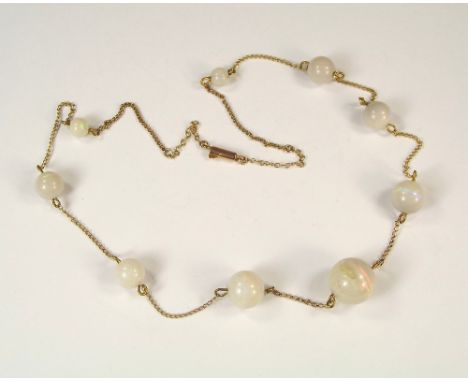 OPAL BEADS. An Edwardian necklet of nine graduated opal beads on rose gold chain.