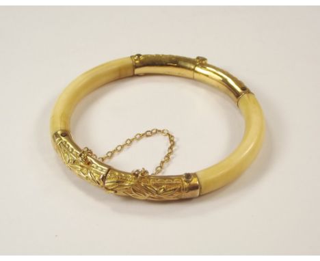 CHINESE BRACELET. A Chinese, 19th century yellow metal mounted ivory bangle. Stamped marks KW, 20 & one other indistinct mark