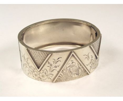VICTORIAN BANGLE. A Victorian hinged bangle, the front engraved a heron.