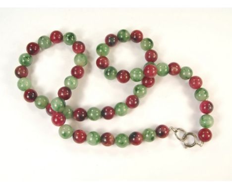 JADE NECKLACE. A green & mulberry antique polished jade necklace.