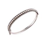 A LATE 19TH CENTURY SILVERED BANGLE SET WITH HALF PEARLS