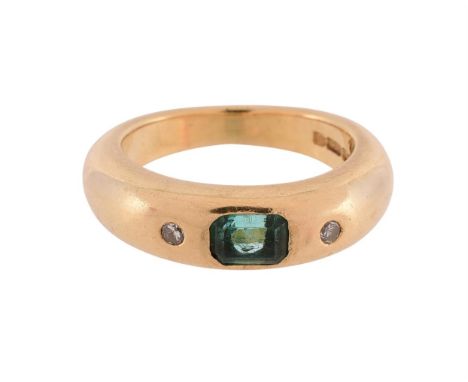 
	
		AN EMERALD AND DIAMOND THREE STONE BAND RING 
		LONDON 1990
		The central step cut emerald with canted corners flanked b