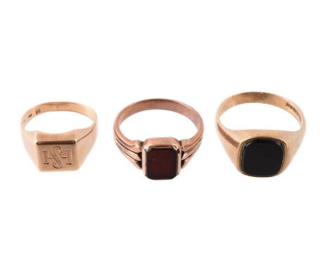 
	
		THREE SIGNET RINGS 
		The first with a squared panel with HS monogram, stamped 585; the second with a polished onyx pane
