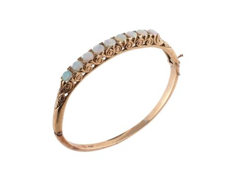 
	
		AN OPAL HINGED BANGLE 
		The front section set with nine circular cabochon opals with a scrolled gallery, the front sect