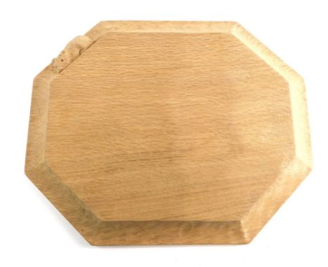 A Robert Thompson of Kilburn Mouseman octagonal oak bread board, with carved mouse to the edge, 31cm wide.