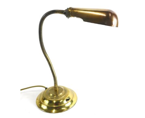 A brass adjustable lamp, with shaped shade and articulated twist stem on stepped base, the shade 17cm long.