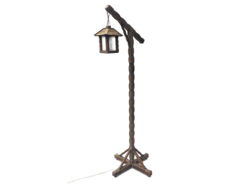 An oak angular tavern standard lamp, with hanging glazed shade, on turned stem and X shaped base, 174cm high. Buyer Note: WAR