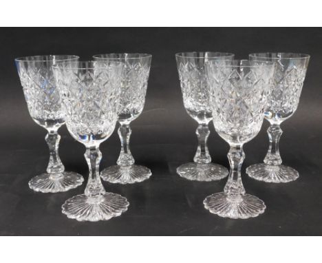 A set of six heavy crystal wine glasses, with a repeat hobnail cut diamond decoration, on shaped stems and flower head feet, 