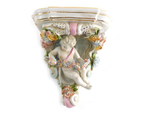 A 20thC Continental porcelain wall shelf, profusely decorated with cherub and garland stem with gild highlighted scroll desig