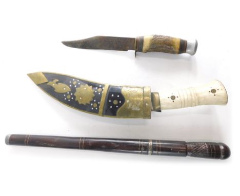A cow horn handled kukri, with shaped scabbard with metal embellishment compressed handle and shaped blade 33cm long, an earl