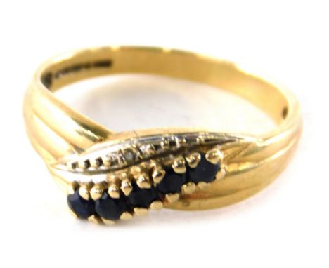 A 9ct gold sapphire and diamond dress ring, of twist design set with five round brilliant cut sapphires and two illusion set 