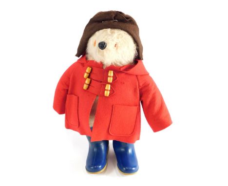 A 20thC plush jointed Paddington Bear, in brown hat with red duffel coat and blue Dunlop marked Wellingtons, 48cm high. 