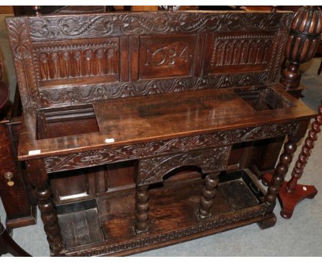 ^ A carved oak stick stand bearing date 1634, the base with two drip trays and bobbin turned supports, 125cm wide 