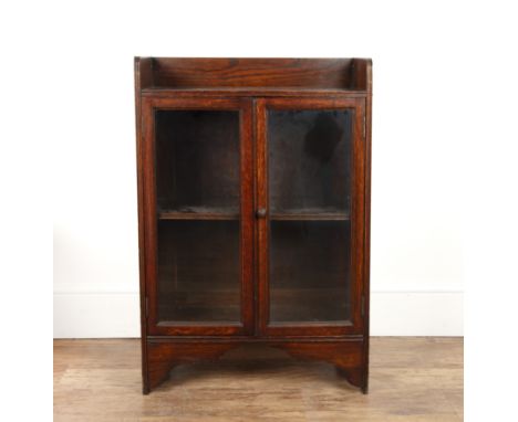 Oak glazed cabinet1930s, with galleried top, turned handles, enclosing a fitted shelf, 60cm wide x 89cm high x 29cm deep appr