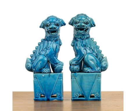 Pair of temple dogsChinese, 20th Century, coated with a turquoise glaze, each dog with scrolling fur and seated rectangular f