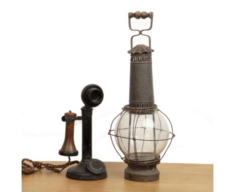 Candlestick phone and a storm lanternthe phone with an indistinct triangular mark to the base, 31cm high approx overall and '