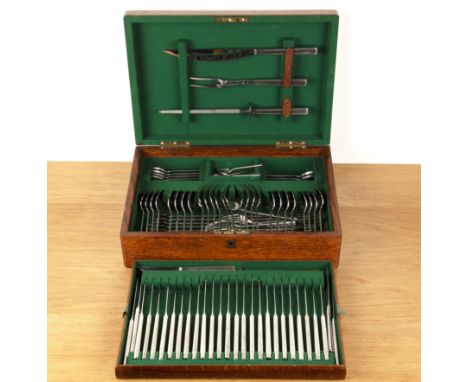 Stainless steel canteen of cutlery in a fitted oak case, the lid with a central brass shield bearing the initials 'G.J.G', th