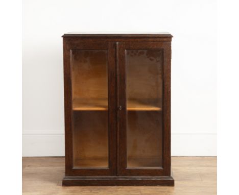 Oak glazed cupboardearly 20th Century, on a plinth base, with an adjustable pine shelf, 59cm wide x 82cm high x 43cm deep app