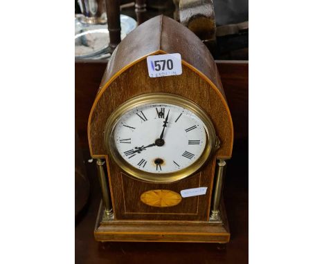 An Edwardian inlaid mahogany mantle clock with brass pillars 