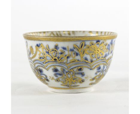 A Meissen blue and white tea bowl, circa 1775, highlighted in gilt, 6cm diameter